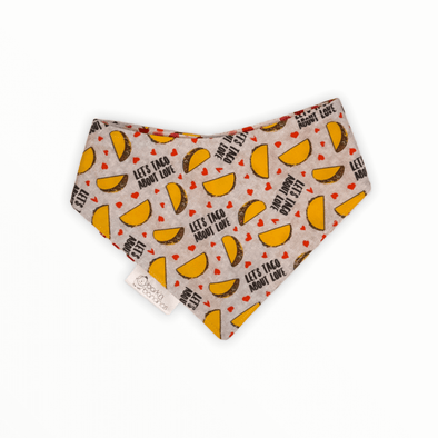 Reversible dog bandana with Tacos and text "Let's Taco About Love!" on one side and small pink hearts on the other side.