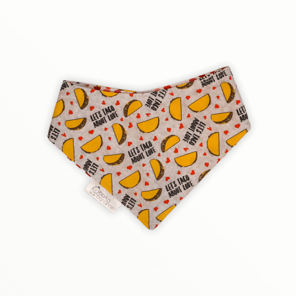 Reversible dog bandana with Tacos and text "Let's Taco About Love!" on one side and small pink hearts on the other side.